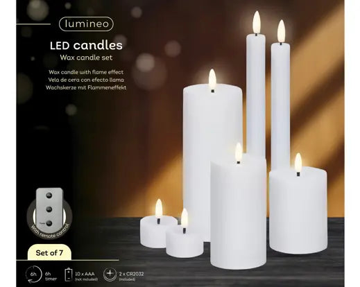 Set of white candles of various sizes with a dimly lit background