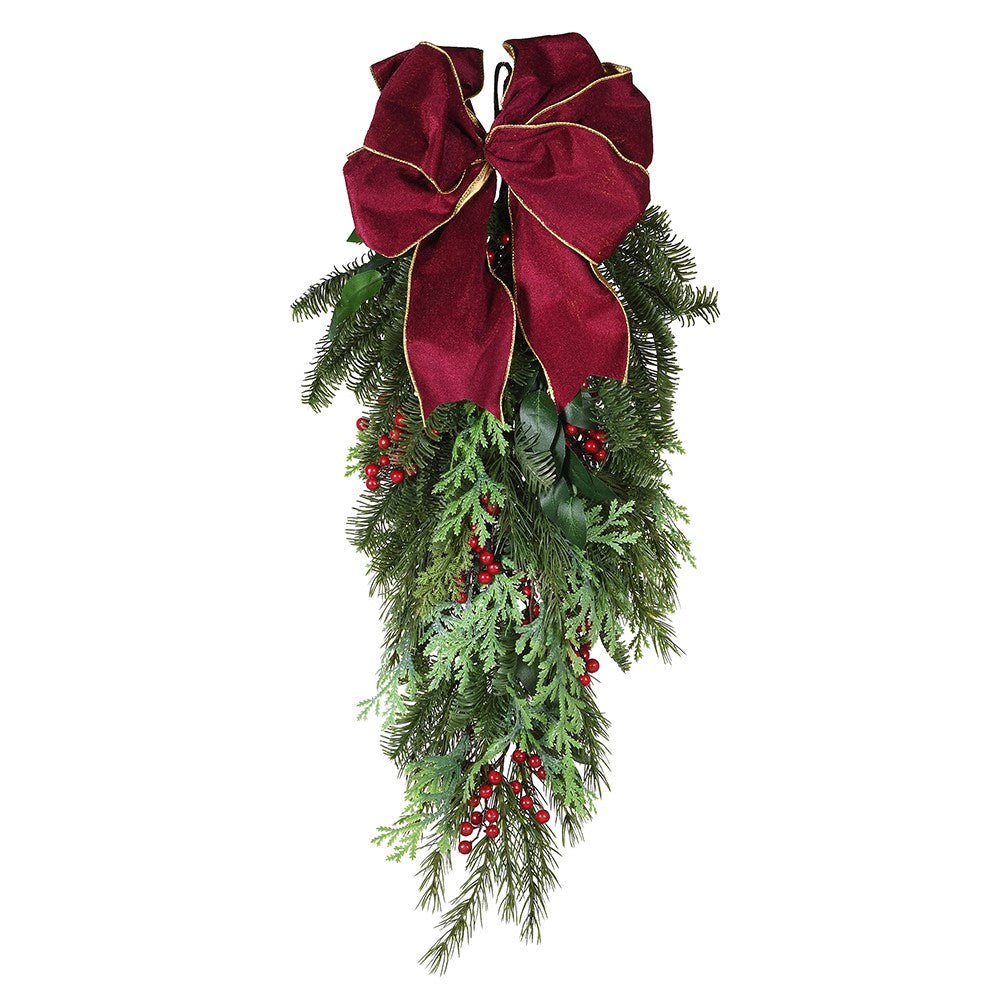 A festive Christmas wreath featuring green fir berries, red accents, and a bow swag on a white background.