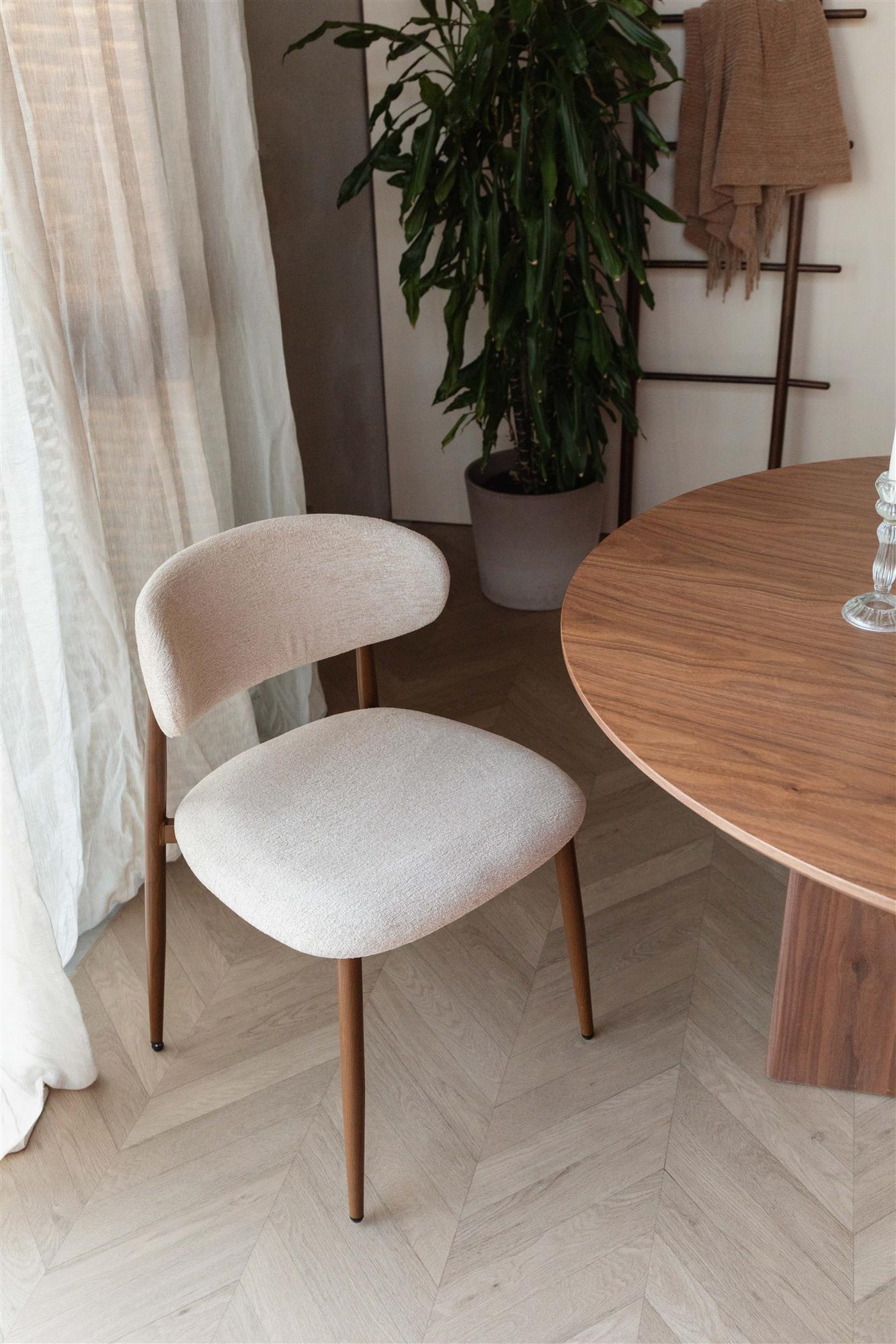 Beige upholstered chair with wooden legs on a white background
