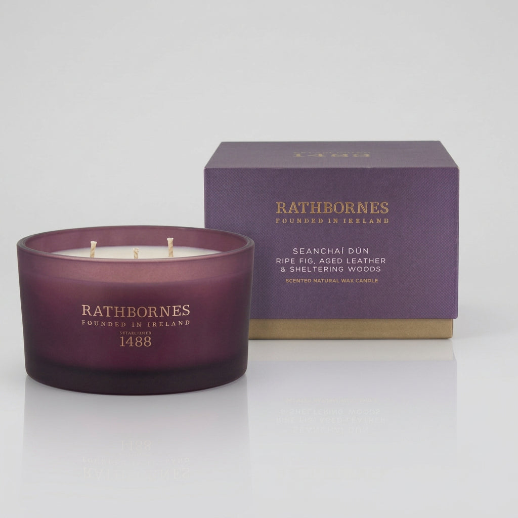 Rathborne's London Candle Collection featuring two scented candles and their packaging on a clean white background. On the left is the '1488' candle in a dark plum glass jar with its purple box.