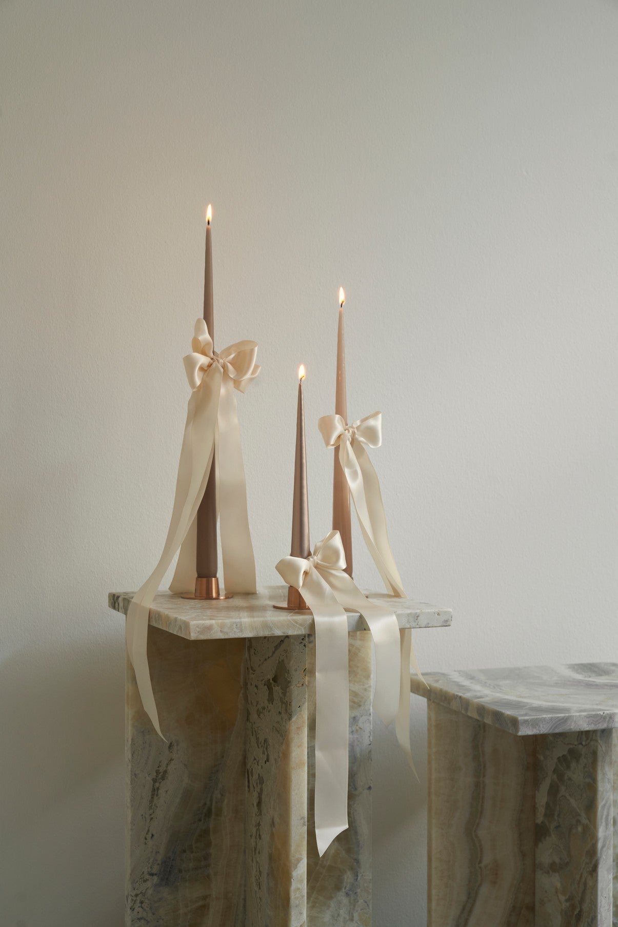 Four slim metallic rose gold tools with tapered ends, arranged vertically side by side on a plain white background.