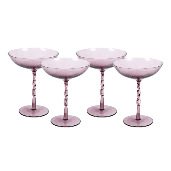 Set of four pink cocktail glasses with twisted stems on a white background