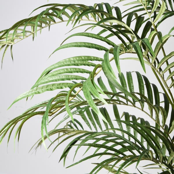 Potted artificial palm plant on a white background
