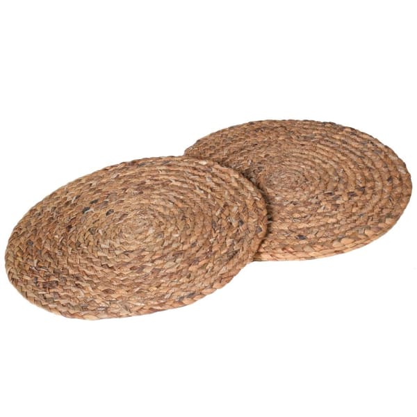 Two round seagrass placemats, with a natural beige color and a textured weave, displayed on a neutral background.