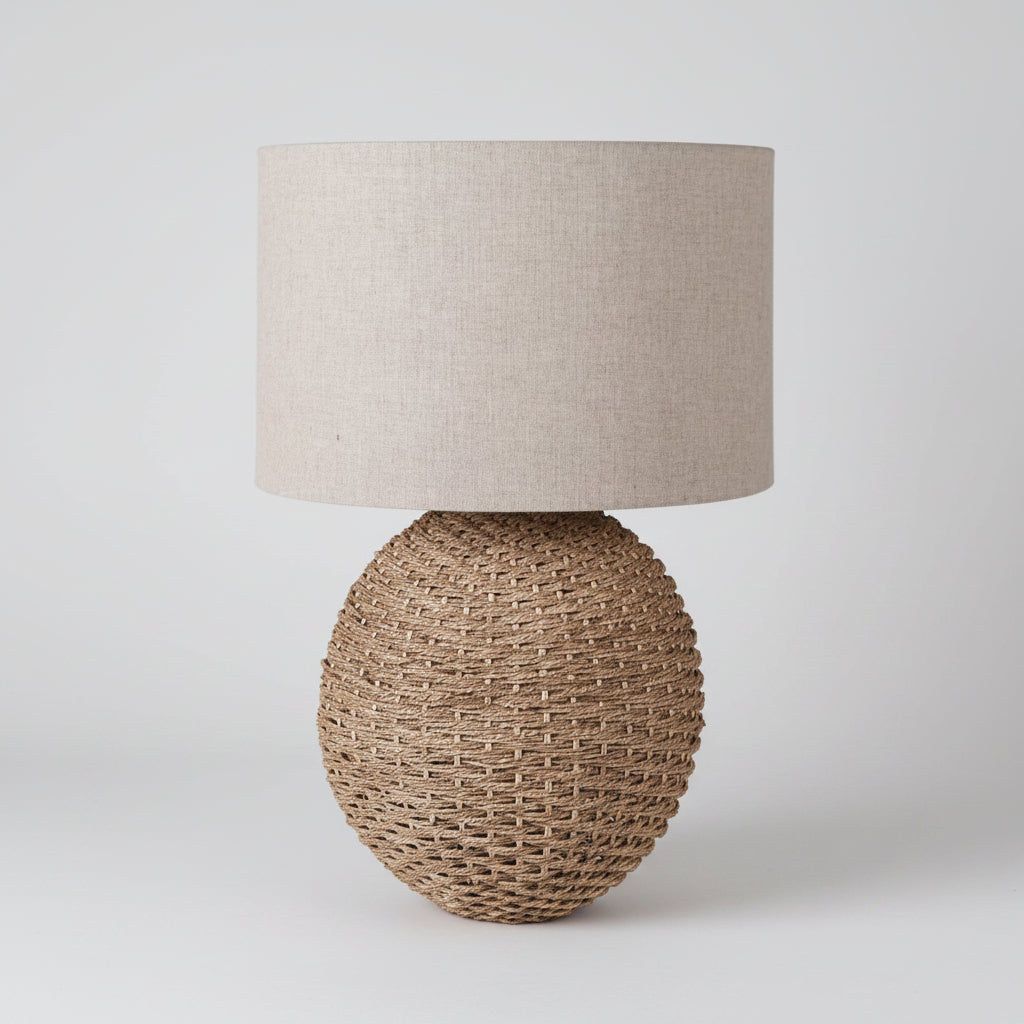 Table lamp with textured beige shade and woven base on a white background